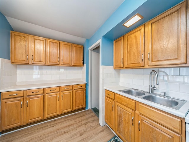 3324 Rollins Ave, Des Moines, IA 50312 - kitchen featuring light countertops, light wood-style flooring, and tasteful backsplash