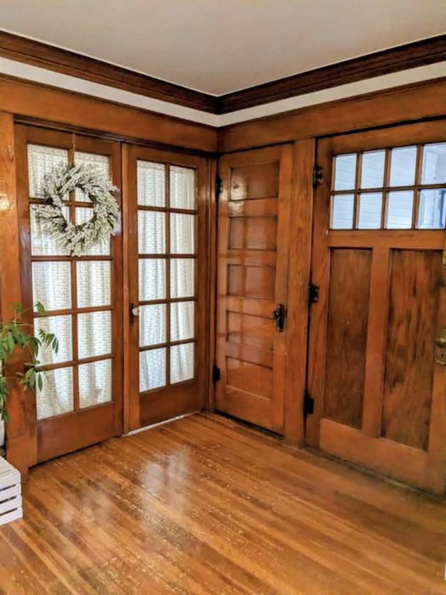 3324 Rollins Ave, Des Moines, IA 50312 - entryway featuring ornamental molding, wood finished floors, healthy amount of natural light, and wood walls