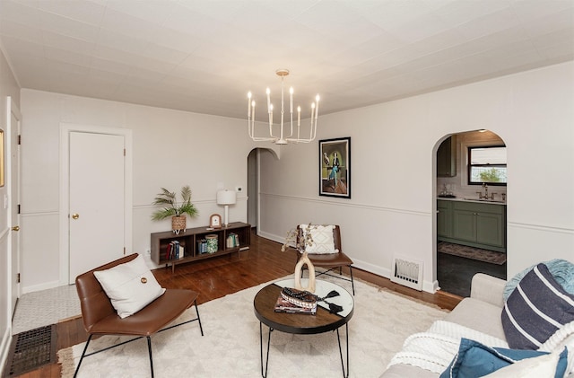 16 E Leach Ave, Des Moines, IA 50315 - living area with arched walkways, wood finished floors, and a chandelier