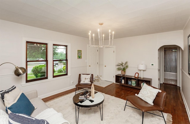 16 E Leach Ave, Des Moines, IA 50315 - living room featuring arched walkways, a chandelier, and wood finished floors