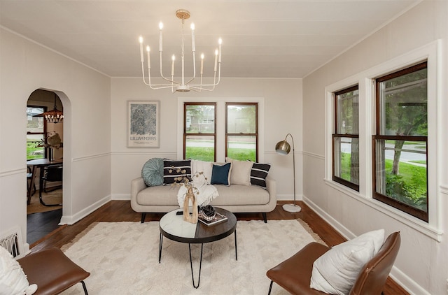 16 E Leach Ave, Des Moines, IA 50315 - living area with healthy amount of natural light, arched walkways, a chandelier, wood finished floors, and ornamental molding