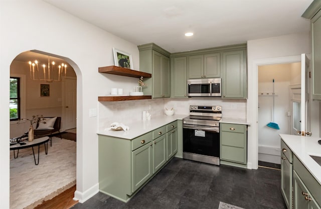 16 E Leach Ave, Des Moines, IA 50315 - kitchen with green cabinets, appliances with stainless steel finishes, arched walkways, light countertops, and open shelves