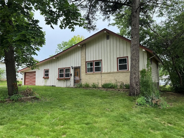 2601 Sherwood Dr, Des Moines, IA 50310 - view of front of property with board and batten siding, a front yard, an attached garage, and brick siding