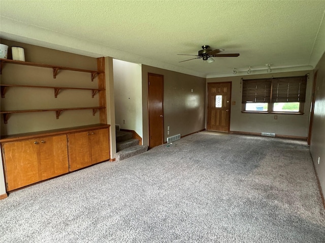 2601 Sherwood Dr, Des Moines, IA 50310 - spare room with carpet floors, ceiling fan, a textured ceiling, stairway, and track lighting