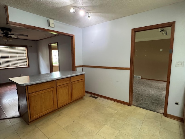 2601 Sherwood Dr, Des Moines, IA 50310 - kitchen with a ceiling fan, brown cabinets, and a textured ceiling