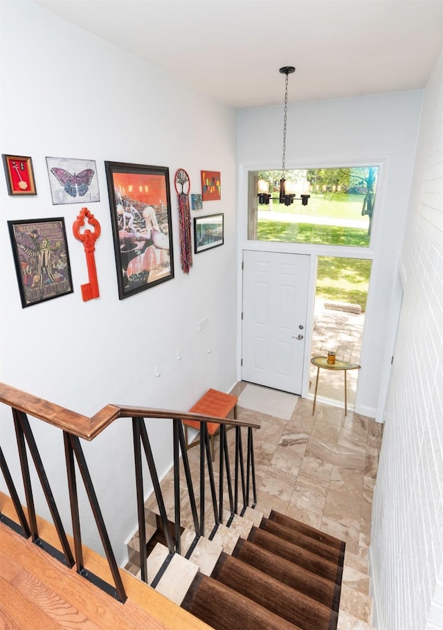 6771 College Ave, Windsor Heights, IA 50324 - entryway featuring a chandelier and stairs