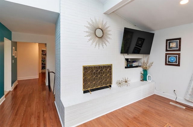 6771 College Ave, Windsor Heights, IA 50324 - living room featuring wood finished floors and a brick fireplace