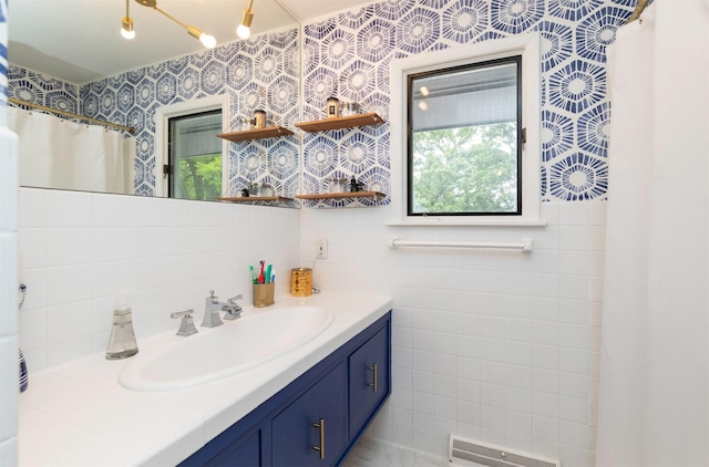 6771 College Ave, Windsor Heights, IA 50324 - full bathroom featuring plenty of natural light, vanity, and tile walls