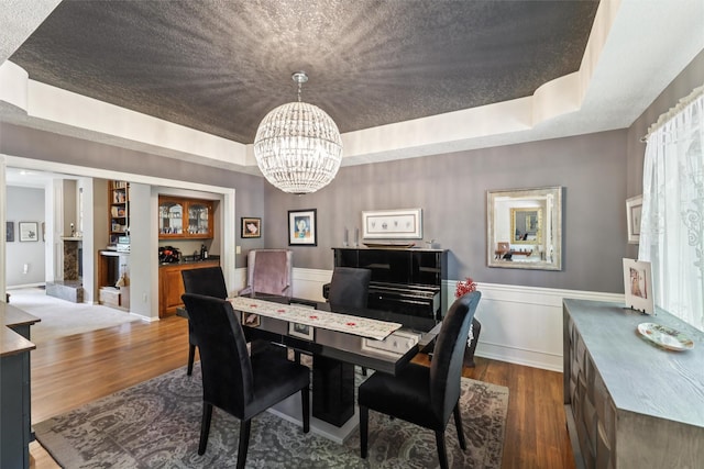 4210 Beaver Hills Dr, Des Moines, IA 50310 - dining area with dark wood finished floors, a tray ceiling, a chandelier, and wainscoting