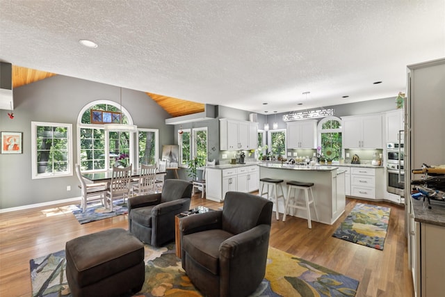 4210 Beaver Hills Dr, Des Moines, IA 50310 - living room featuring wood finished floors, a textured ceiling, lofted ceiling, and recessed lighting