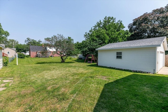 2325 61st St, Des Moines, IA 50322 - view of grassy yard featuring a playground, an outdoor structure, and a garage