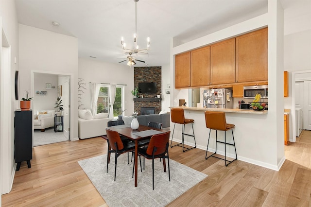 6350 Coachlight Dr Unit 1308, West Des Moines, IA 50266 - dining space featuring a chandelier, light wood-style flooring, and a fireplace