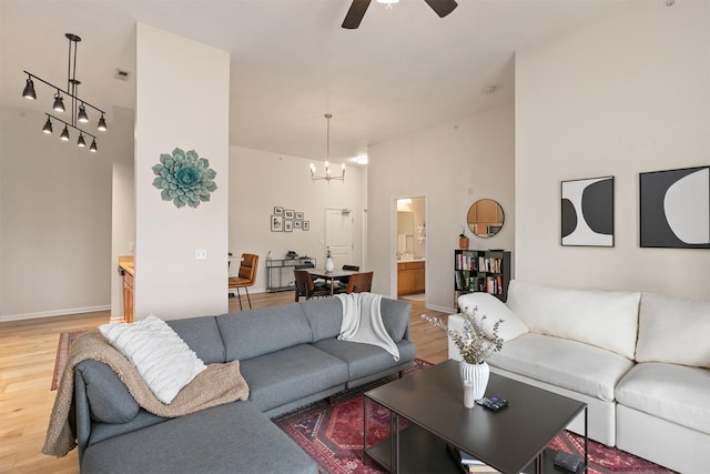 6350 Coachlight Dr Unit 1308, West Des Moines, IA 50266 - living room with light wood finished floors, ceiling fan, and a chandelier
