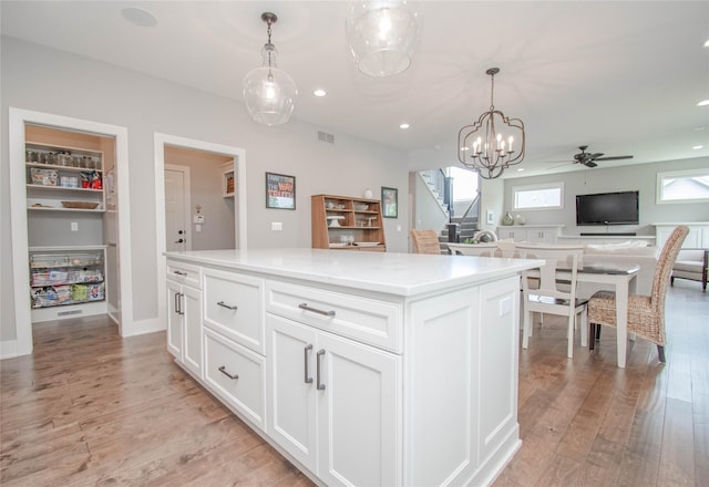 2416 NW Springbrooke Dr, Grimes, IA 50111 - kitchen with light wood-style flooring, white cabinetry, recessed lighting, open floor plan, and pendant lighting
