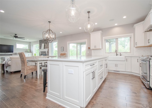 2416 NW Springbrooke Dr, Grimes, IA 50111 - kitchen with stainless steel range, recessed lighting, open floor plan, decorative backsplash, and plenty of natural light