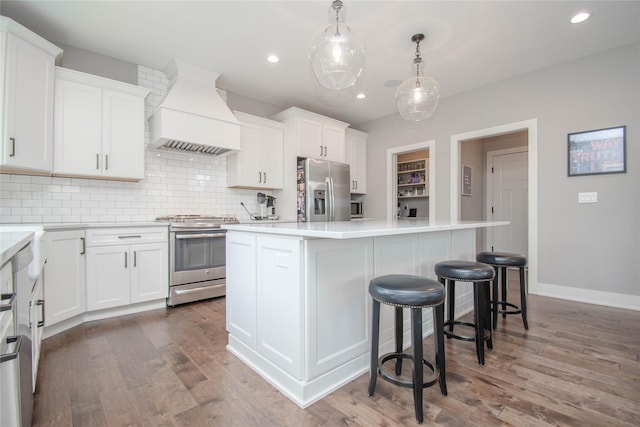 2416 NW Springbrooke Dr, Grimes, IA 50111 - kitchen with stainless steel appliances, custom exhaust hood, wood finished floors, a center island, and backsplash