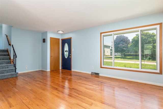 7013 Twana Dr, Urbandale, IA 50322 - unfurnished living room featuring stairs and light wood-type flooring
