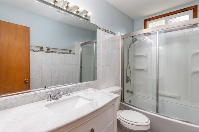 7013 Twana Dr, Urbandale, IA 50322 - bathroom with tile walls, vanity, and enclosed tub / shower combo