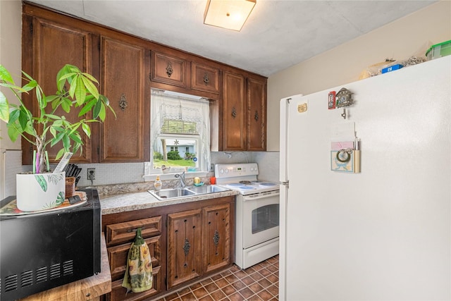 2326 Adams Ave, Des Moines, IA 50310 - kitchen with white appliances, decorative backsplash, light countertops, and brown cabinetry