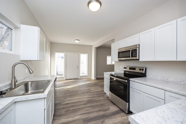 1332 E Sheridan Ave, Des Moines, IA 50316 - kitchen with stainless steel appliances, light countertops, white cabinets, and dark wood-type flooring