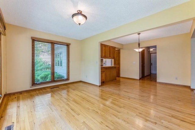 520 34th Pl, West Des Moines, IA 50265 - unfurnished living room with light wood-style flooring and a textured ceiling