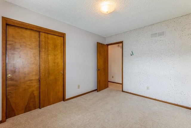 520 34th Pl, West Des Moines, IA 50265 - unfurnished bedroom with light colored carpet, a closet, and a textured ceiling