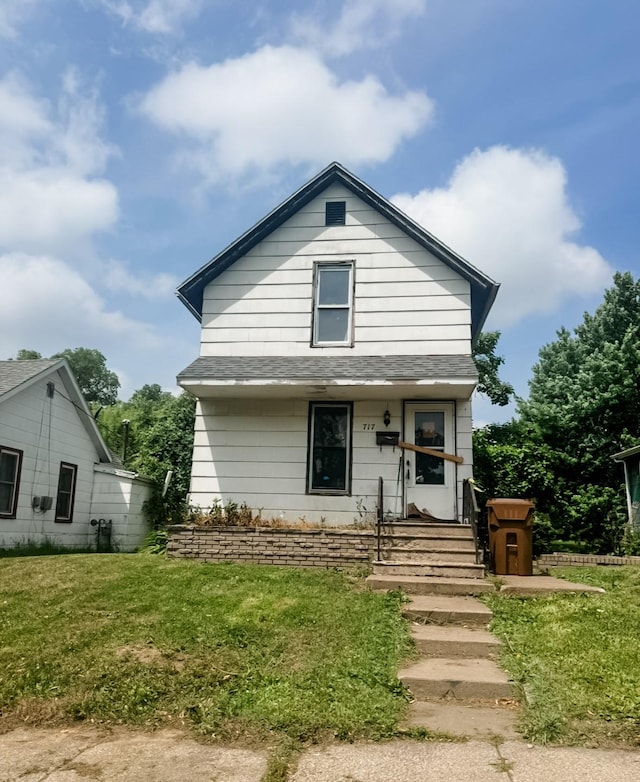 717 Pearl St, Grinnell, IA 50112 - view of front of house with a front lawn and a shingled roof