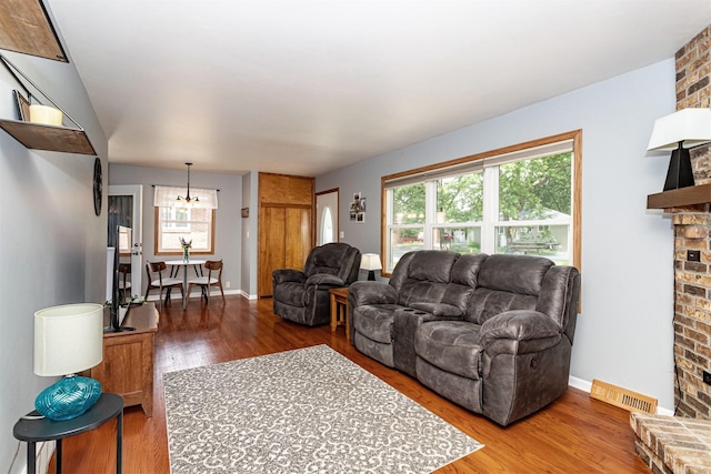 1621 Carroll Ave, Ames, IA 50010 - living room with wood finished floors, a fireplace, and a chandelier