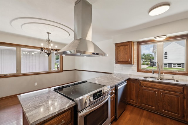 506 2nd Ave SW, Altoona, IA 50009 - kitchen featuring appliances with stainless steel finishes, island exhaust hood, backsplash, dark wood-type flooring, and light stone countertops