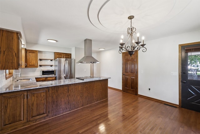 506 2nd Ave SW, Altoona, IA 50009 - kitchen with freestanding refrigerator, exhaust hood, decorative backsplash, light stone countertops, and a peninsula