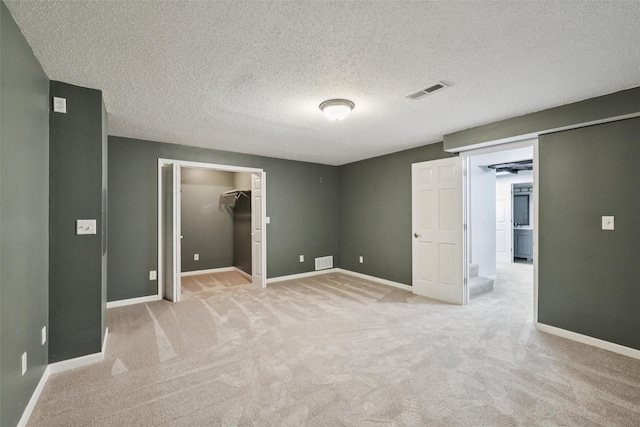 506 2nd Ave SW, Altoona, IA 50009 - unfurnished bedroom with light carpet, a spacious closet, and a textured ceiling