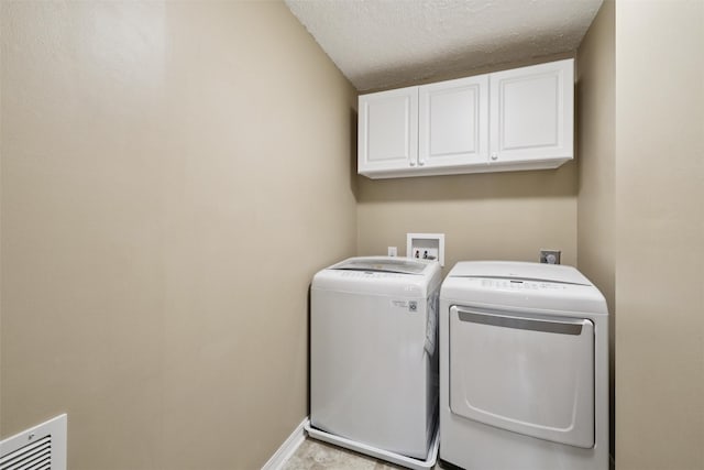 506 2nd Ave SW, Altoona, IA 50009 - laundry room with cabinet space, independent washer and dryer, and a textured ceiling