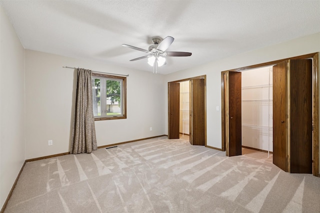 506 2nd Ave SW, Altoona, IA 50009 - unfurnished bedroom featuring two closets, light colored carpet, and ceiling fan