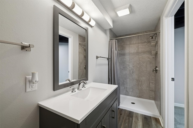 506 2nd Ave SW, Altoona, IA 50009 - full bathroom featuring vanity, a tile shower, and wood finished floors