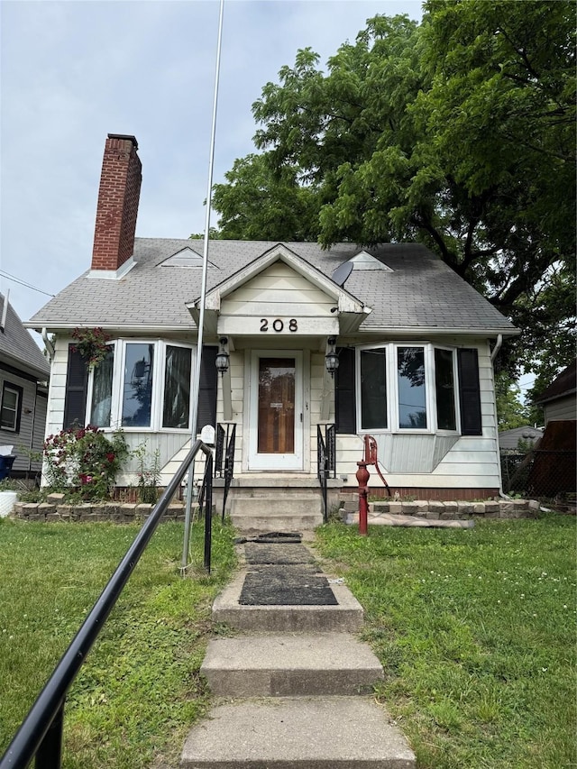 208 E 16th St, Des Moines, IA 50316 - bungalow featuring a chimney, a shingled roof, and a front lawn