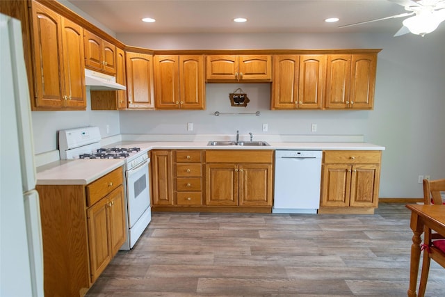 106 Park Ridge Dr, Otley, IA 50214 - kitchen with white appliances, under cabinet range hood, brown cabinetry, and recessed lighting