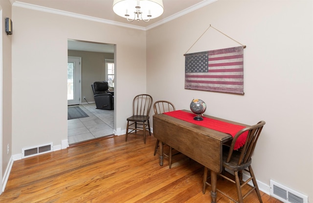 1808 60th St, Des Moines, IA 50322 - dining space with crown molding, wood finished floors, and a chandelier