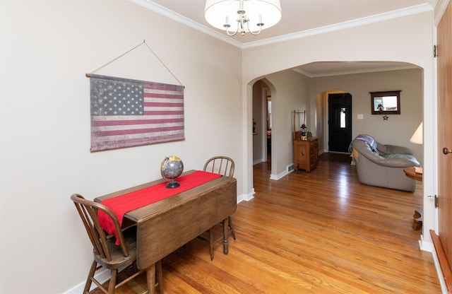 1808 60th St, Des Moines, IA 50322 - dining area featuring arched walkways, a chandelier, light wood-style flooring, and ornamental molding