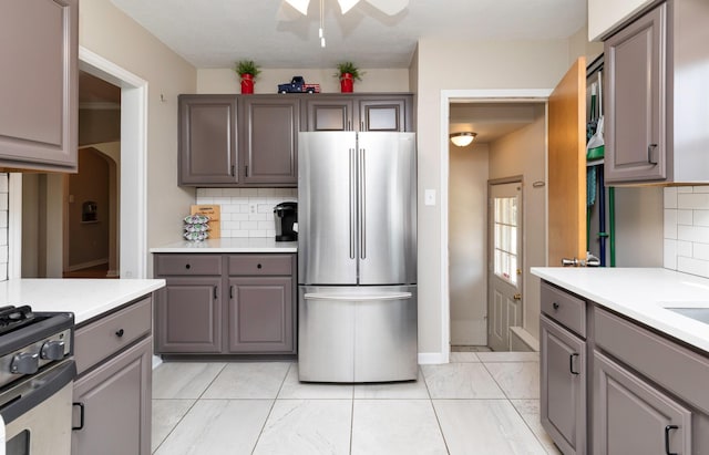 1808 60th St, Des Moines, IA 50322 - kitchen with appliances with stainless steel finishes, gray cabinetry, backsplash, and light countertops