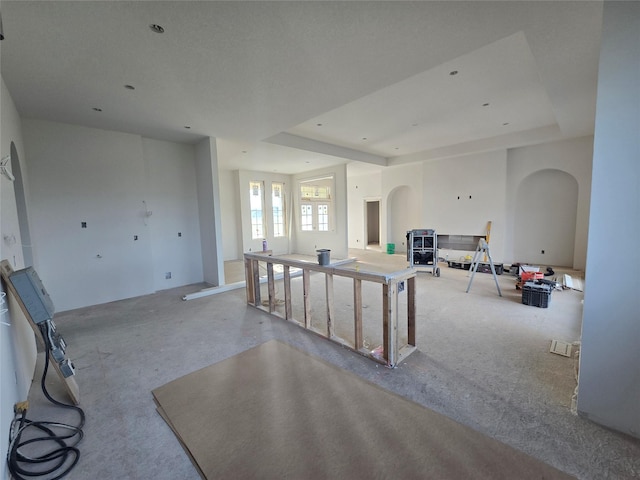 4617 Centennial Blvd, Urbandale, IA 50323 - living area with a tray ceiling, arched walkways, and carpet floors