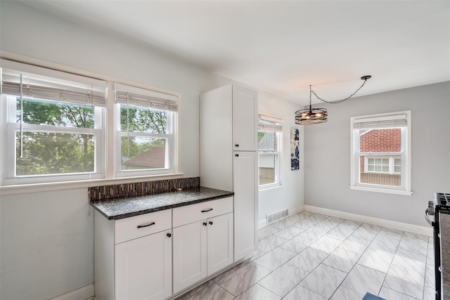 1329 63rd St, Des Moines, IA 50311 - kitchen featuring light marble finish floors, white cabinetry, a chandelier, and gas stove
