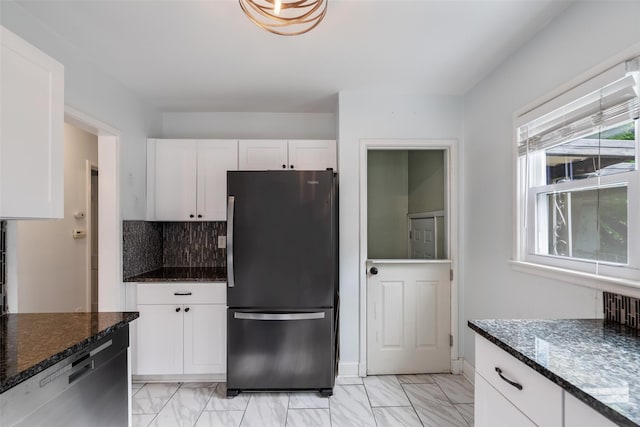 1329 63rd St, Des Moines, IA 50311 - kitchen with stainless steel appliances, light marble finish floors, white cabinetry, and dark stone countertops