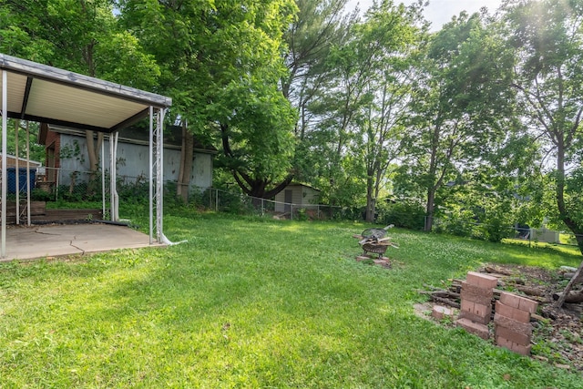 1329 63rd St, Des Moines, IA 50311 - fenced backyard featuring an outdoor fire pit and a patio area