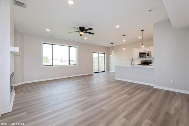 7000 Lake Hill Dr Unit 74, Des Moines, IA 50320 - unfurnished living room with recessed lighting, a ceiling fan, and light wood-style flooring