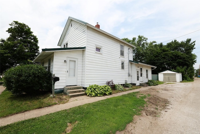 615 11th St, Boone, IA 50036 - view of front facade featuring entry steps, a chimney, an outdoor structure, and a detached garage