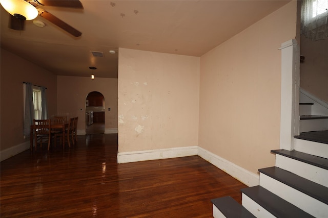 615 11th St, Boone, IA 50036 - unfurnished living room featuring arched walkways, ceiling fan, wood finished floors, and stairs