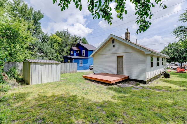 1512 2nd Pl, Des Moines, IA 50314 - rear view of house featuring a wooden deck, a storage unit, and a chimney
