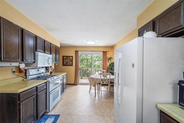 516 Walnut St, De Soto, IA 50069 - kitchen with white appliances, dark brown cabinetry, and light countertops