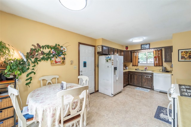 516 Walnut St, De Soto, IA 50069 - kitchen featuring white appliances, dark brown cabinetry, and light countertops