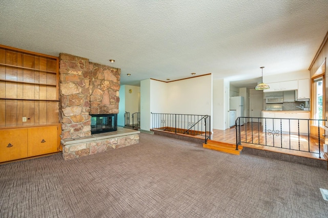1005 32nd St, West Des Moines, IA 50266 - unfurnished living room with carpet floors, a textured ceiling, and a fireplace